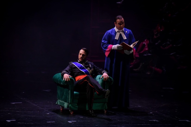 Luka Jozic seated in a green armchair beside a clerk