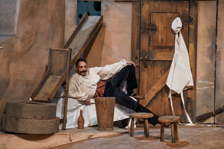 Luka Jozic reclining in a rustic barn set