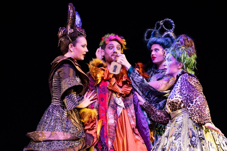 Papageno with a padlock, surrounded by three richly costumed ladies