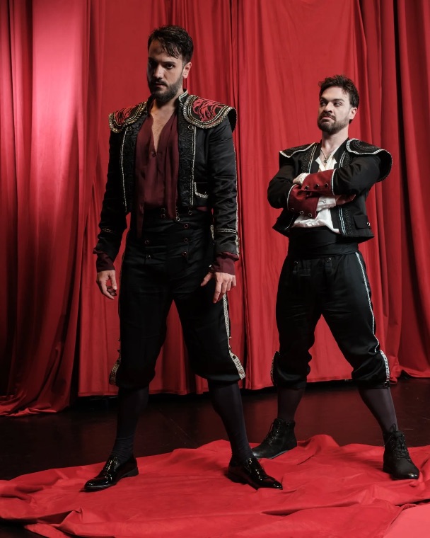 Luka Jozic and a fellow performer in matador costume before a red curtain